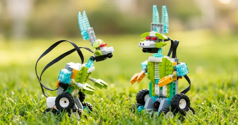 Две собранные модели-робота из конструктора РобоГуру, совместимого с WeDo 2.0, на траве — пример того, что можно собрать из набора