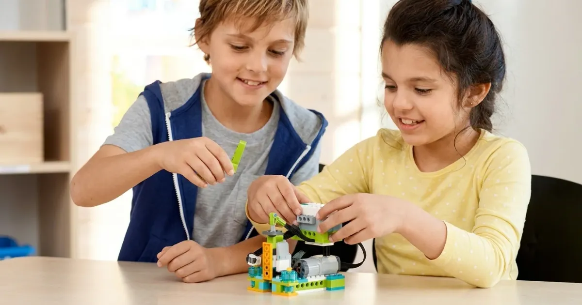 Двое детей собирают модель робота из набора WeDo 2.0 — сравнение робототехники и обычного конструктора
